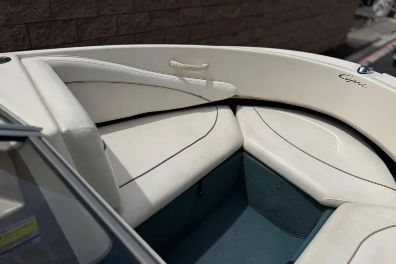 Slide: The Image of Interior of a 2000 Bayliner 2150 Capri boat with white seating and blue carpet. - 9