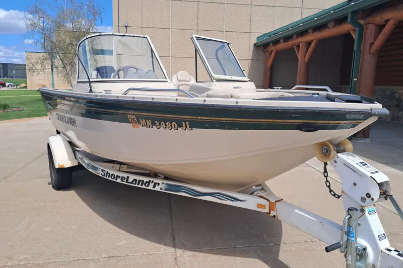 The Image of 2002 Crestliner 1850 Sportfish boat on trailer, parked outdoors. - 1