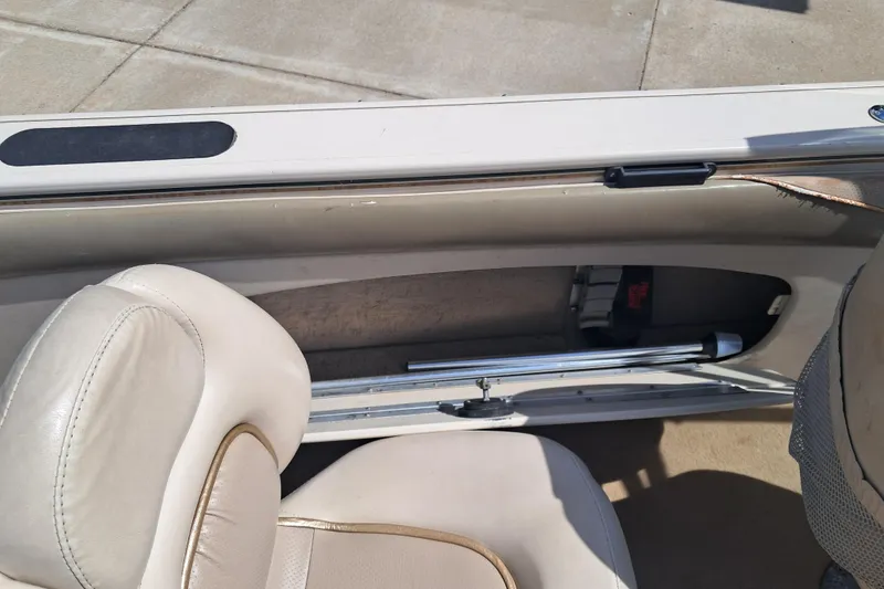 Slide: The Image of 2002 Crestliner 1850 Sportfish interior with beige seating and storage compartment. - 10