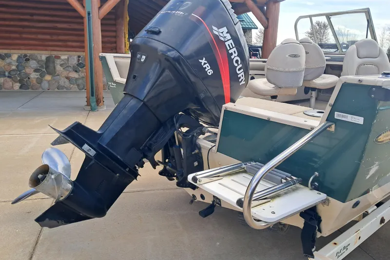 Slide: The Image of 2002 Crestliner 1850 Sportfish boat with Mercury XR6 outboard motor, docked outdoors. - 4