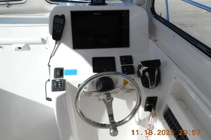 Slide: The Image of Helm of 2021 NorthCoast 235 HT boat with steering wheel and control panel. - 2