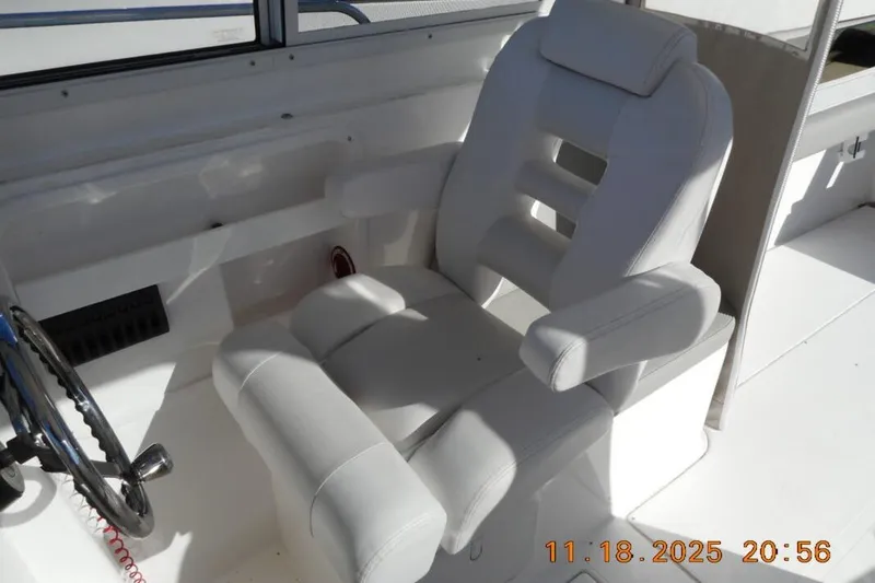 Slide: The Image of Captain's chair in 2021 NorthCoast 235 HT boat cockpit, featuring sleek white design. - 4