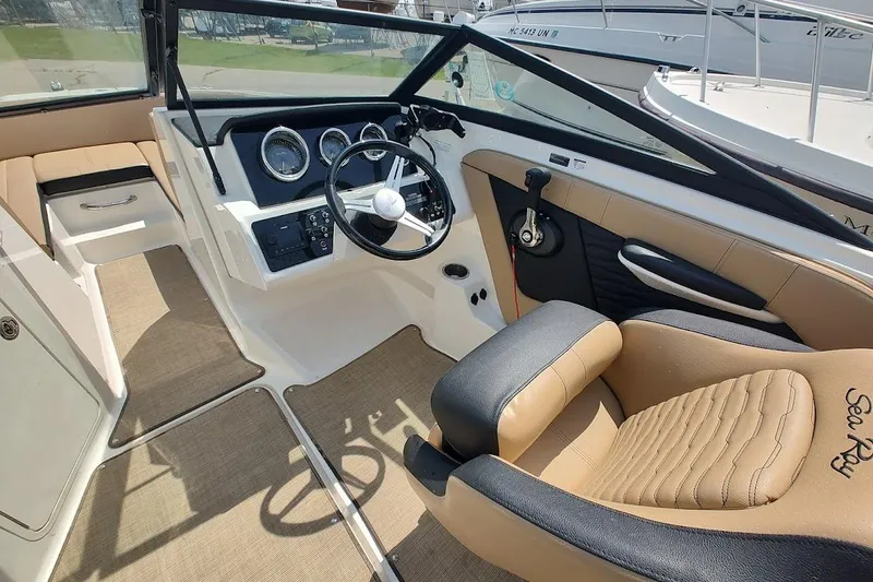 Slide: The Image of 2023 Sea Ray SPX 190 boat interior with beige and black seating, modern dashboard. - 12