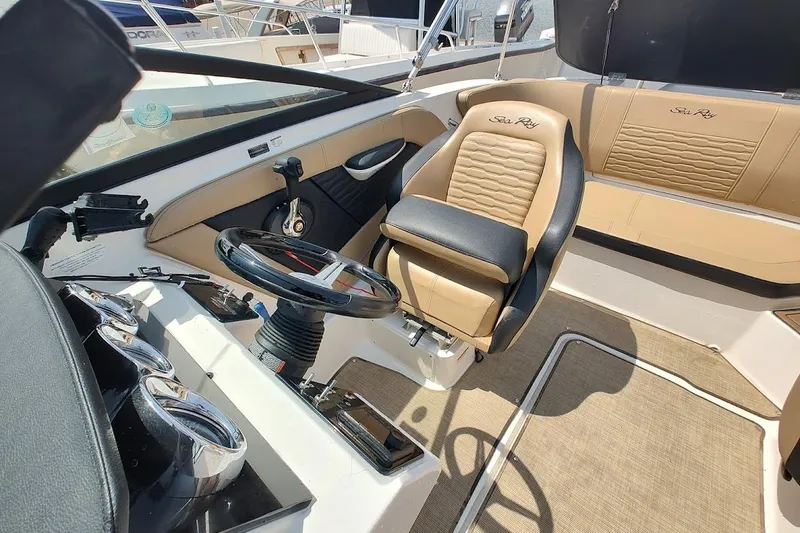Slide: The Image of 2023 Sea Ray SPX 190 boat interior with tan and black seating, steering wheel, and dashboard controls. - 16