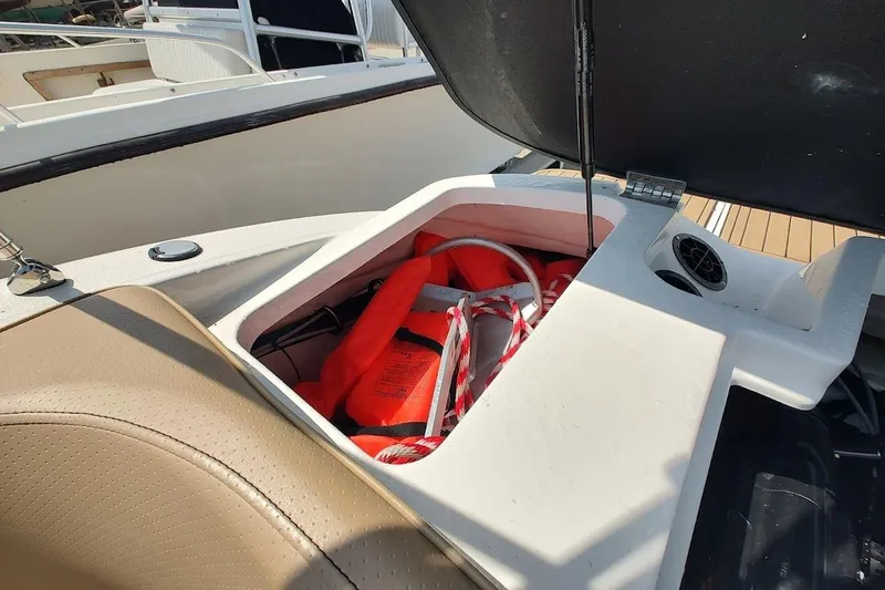 Slide: The Image of Storage compartment on 2023 Sea Ray SPX 190 boat with life jackets and rope. - 19