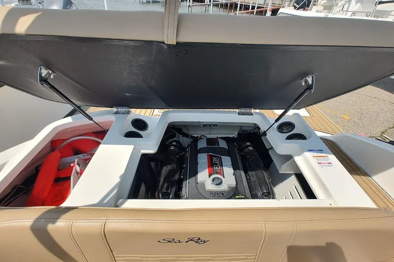Slide: The Image of 2023 Sea Ray SPX 190 boat engine compartment with open hatch, revealing engine and storage. - 20