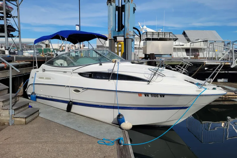 The Image of 2007 Bayliner 245 Cruiser docked at a marina with blue canopy. - 0