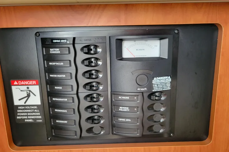 Slide: The Image of Electrical control panel on a 2007 Bayliner 245 Cruiser with voltage meter and safety warnings. - 26