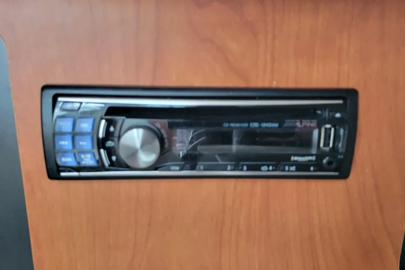 Slide: The Image of 2007 Bayliner 245 Cruiser stereo system with USB and CD player on wooden panel. - 27