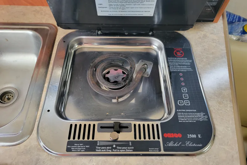Slide: The Image of Stove in 2007 Bayliner 245 Cruiser boat kitchen, featuring alcohol burner and control panel. - 33