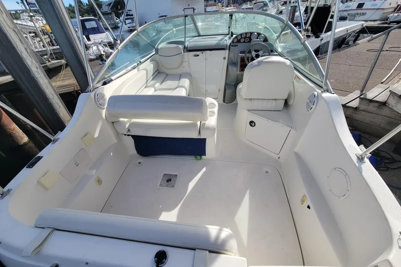 Slide: The Image of 2007 Bayliner 245 Cruiser boat interior with seating and steering wheel at a marina. - 5