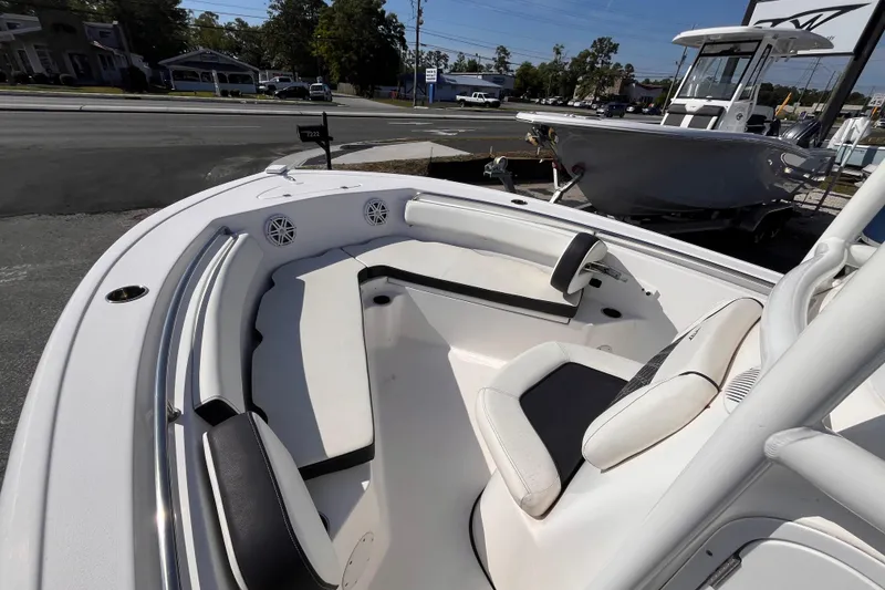 Slide: The Image of 2022 Tidewater 210 LXF boat interior with seating and speakers, displayed outdoors. - 12