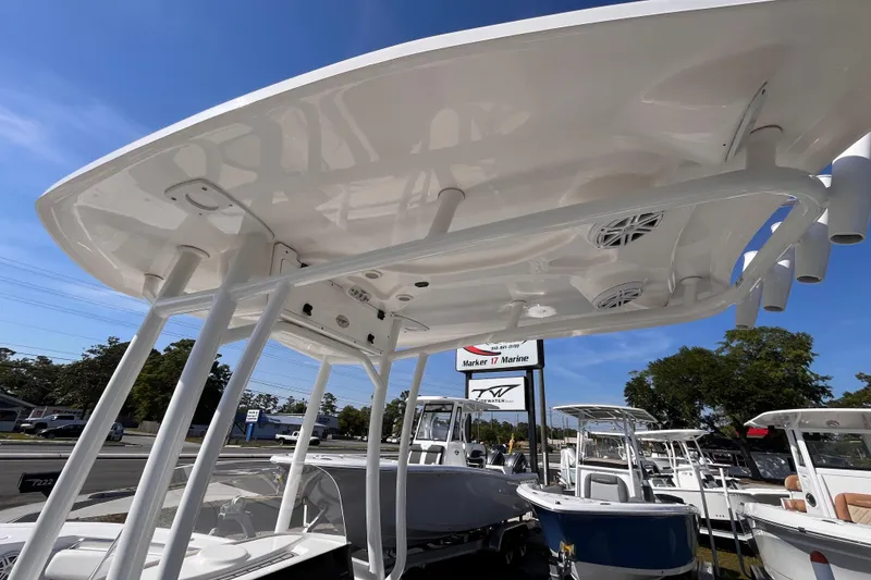 Slide: The Image of 2022 Tidewater 210 LXF boat with T-top and speakers, displayed at a marine dealership. - 15