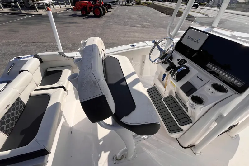 Slide: The Image of 2022 Tidewater 210 LXF boat interior with seating and Garmin navigation system. - 6