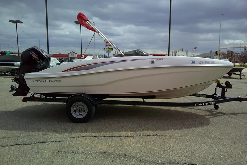 Slide: The Image of 2024 Tahoe T18 boat on trailer in parking lot, overcast sky background. - 4