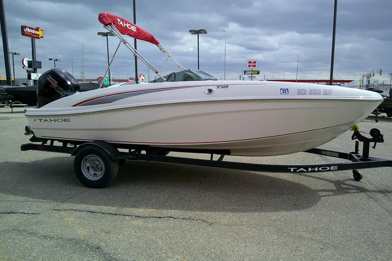 Slide: The Image of 2024 Tahoe T18 boat on trailer in parking lot, overcast sky. - 5