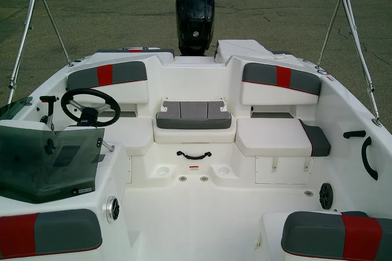Slide: The Image of 2024 Tahoe T18 boat interior with gray and red seating, steering wheel, and storage compartments. - 7