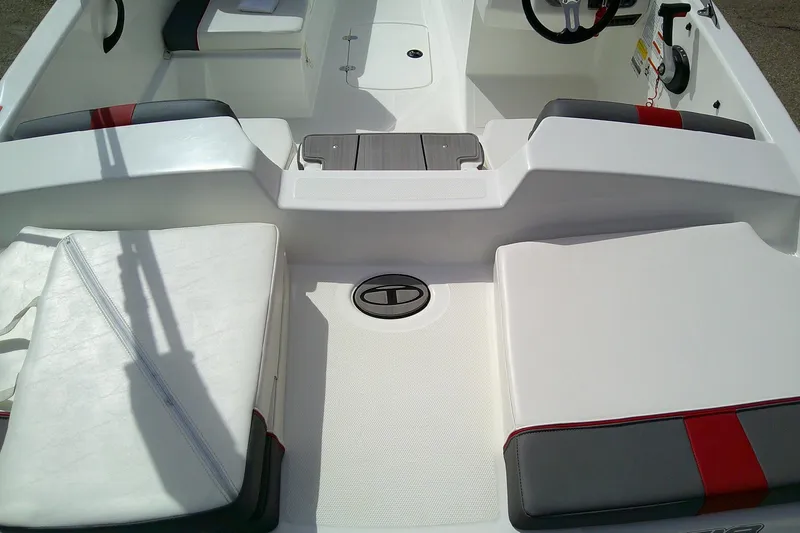 Slide: The Image of 2024 Tahoe T18 boat interior with white and gray seating, red accents, and steering wheel. - 8