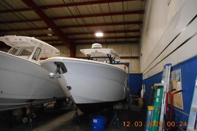 The Image of 2023 Sea Fox 288 Commander boat in a warehouse, surrounded by equipment and tools. - 0