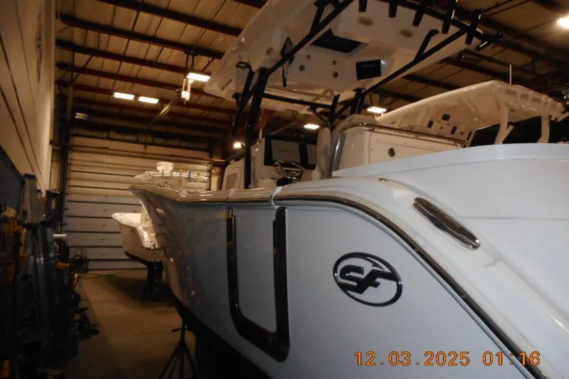 Slide: The Image of 2023 Sea Fox 288 Commander boat in a warehouse, showcasing sleek design and logo. - 2