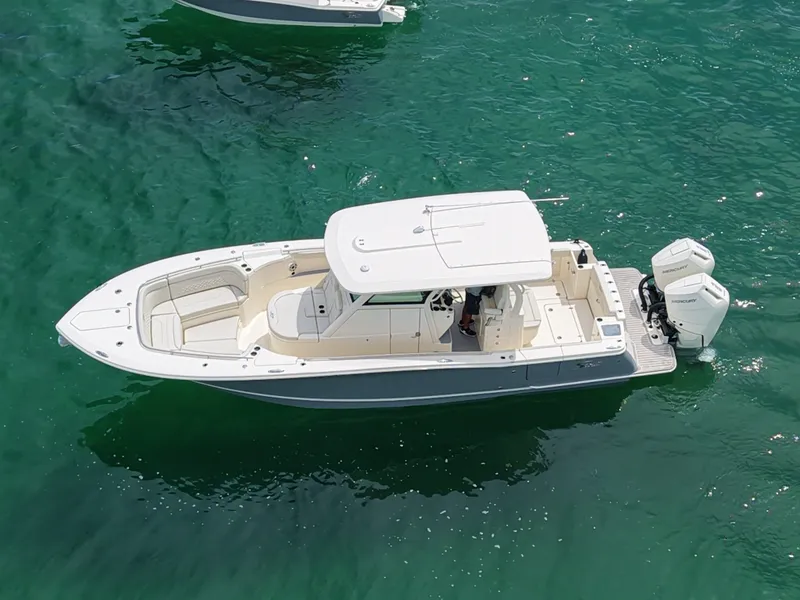 Slide: The Image of A 2027 Scout 330 LXF on clear water with two outboard engines. - 7