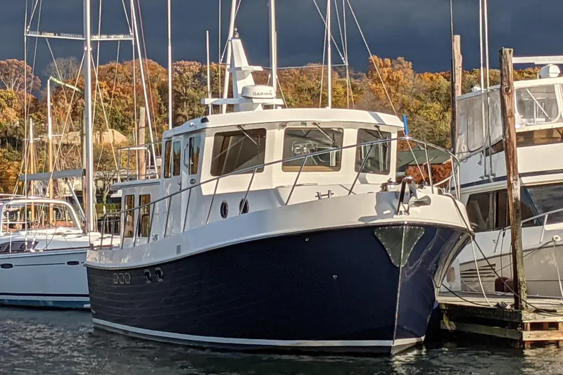 The Image of 2005 American Tug 41 docked in harbor, surrounded by autumn trees. - 0