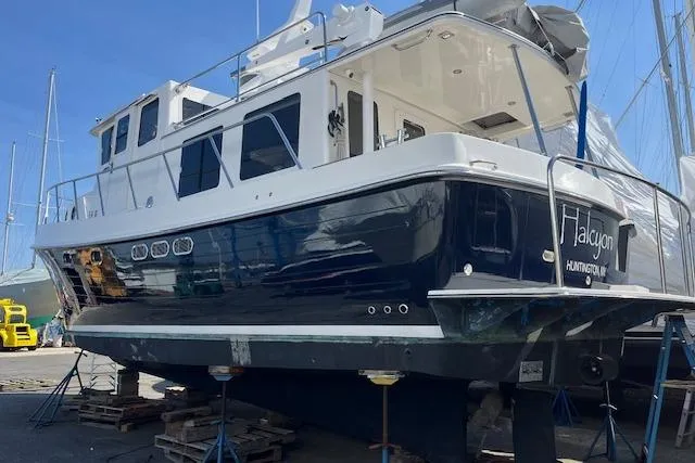 Slide: The Image of 2005 American Tug 41 boat on dry dock, blue and white exterior, side view. - 1