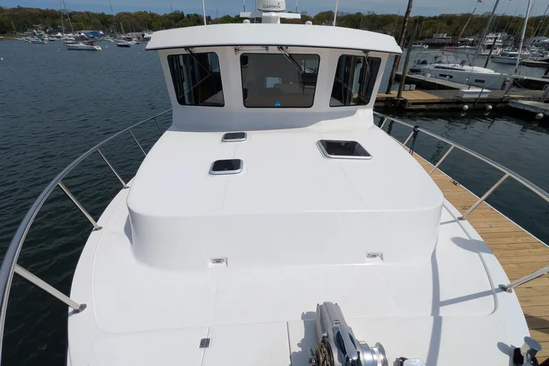 Slide: The Image of 2005 American Tug 41 docked at marina, showcasing spacious deck and cabin windows. - 15