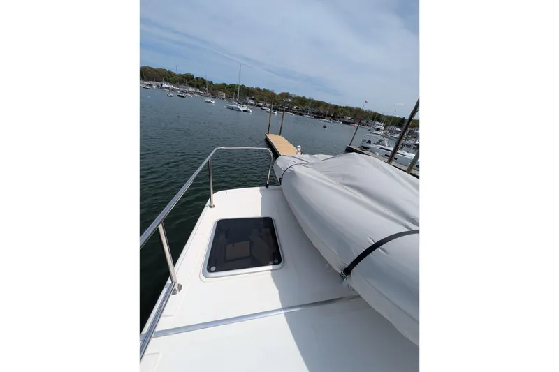 Slide: The Image of 2005 American Tug 41 docked, featuring deck view with hatch and covered equipment. - 24