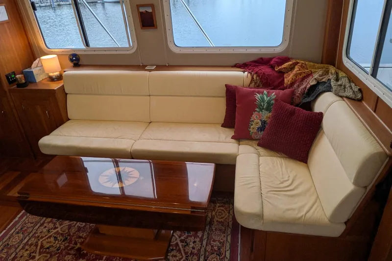 Slide: The Image of Interior of 2005 American Tug 41 with cream sofa, colorful pillows, and wooden table. - 25