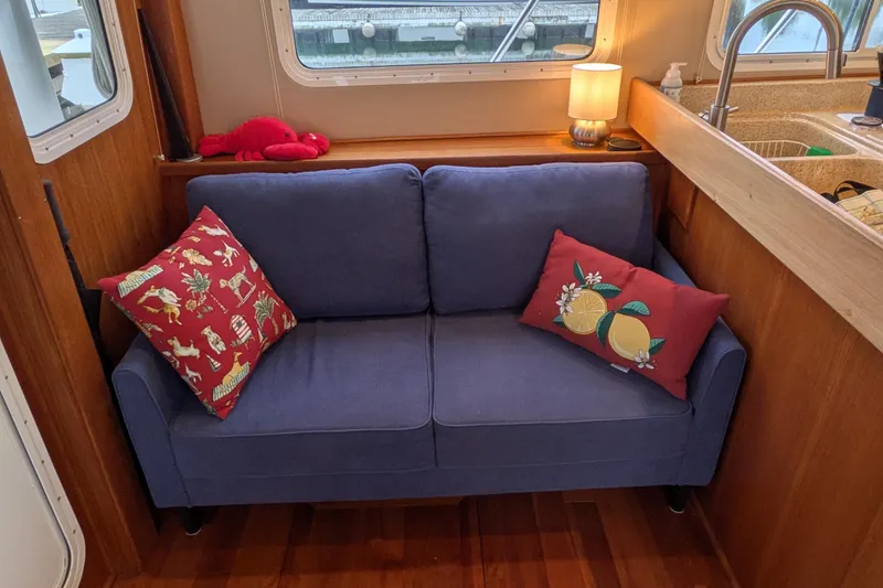 Slide: The Image of Cozy interior of 2005 American Tug 41 with blue sofa and decorative pillows. - 26