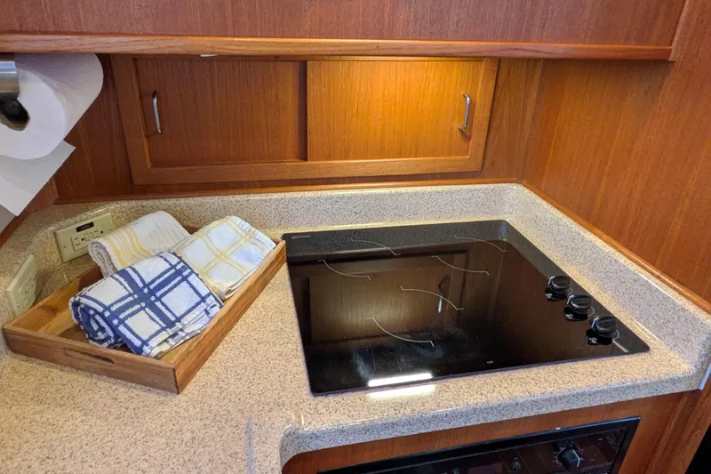 Slide: The Image of 2005 American Tug 41 kitchen with electric stove and wooden cabinetry. - 27
