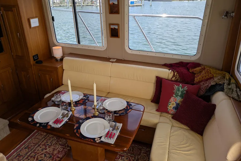 Slide: The Image of Luxurious dining area inside a 2005 American Tug 41 yacht, elegantly set for four. - 28