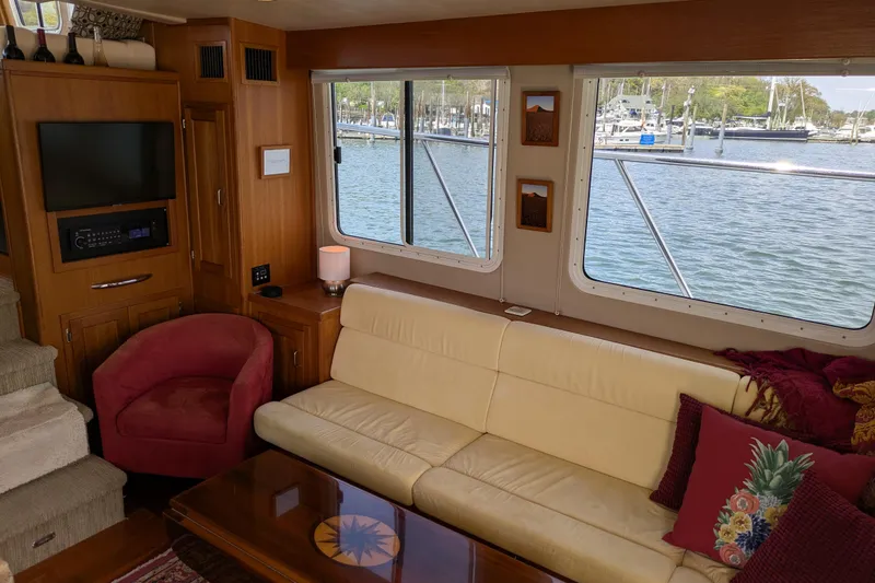 Slide: The Image of Interior of 2005 American Tug 41 with sofa, armchair, and waterfront view. - 29