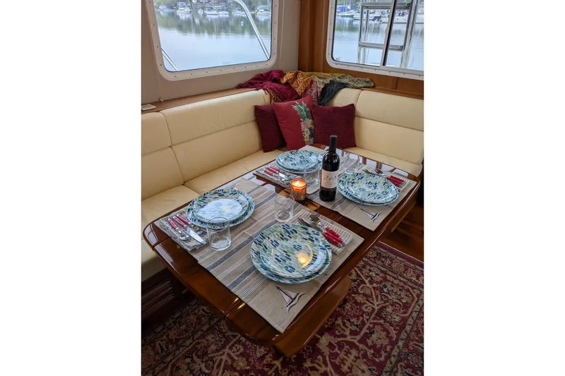 Slide: The Image of Elegant dining setup in 2005 American Tug 41 yacht interior with scenic window view. - 30