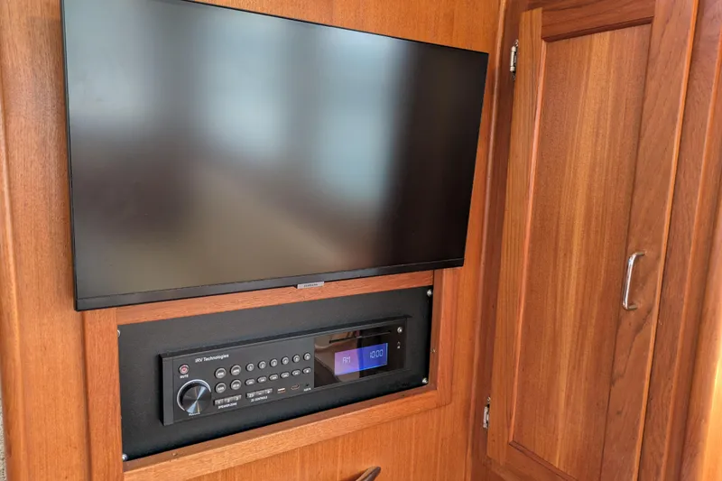 Slide: The Image of Flat-screen TV and control panel in 2005 American Tug 41 boat interior. - 32