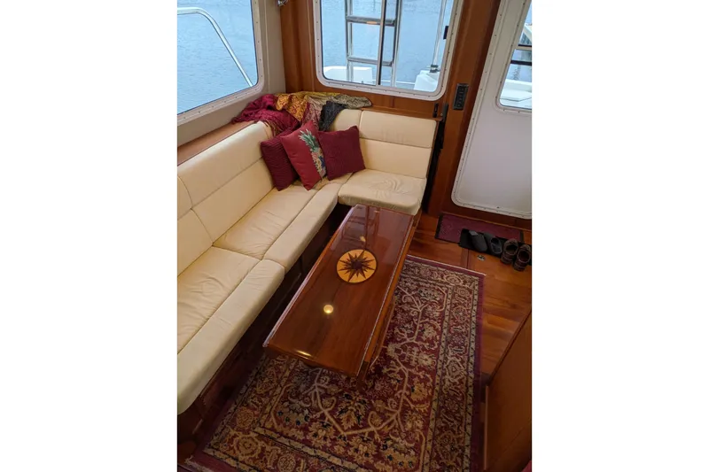 Slide: The Image of Interior of 2005 American Tug 41 with beige seating, wooden table, and decorative rug. - 34