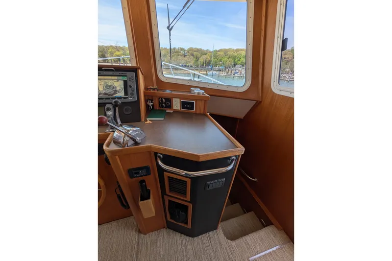 Slide: The Image of Pilothouse interior of 2005 American Tug 41, featuring navigation equipment and scenic window view. - 35