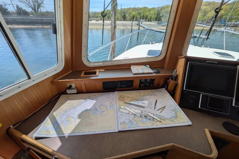 Slide: The Image of Pilothouse of 2005 American Tug 41 with navigation charts and instruments. - 42