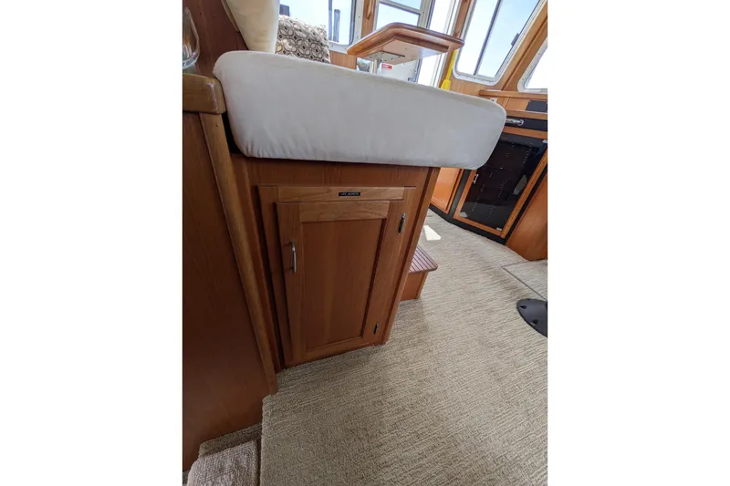 Slide: The Image of Interior of 2005 American Tug 41, featuring wooden cabinetry and cushioned seating. - 47