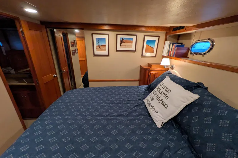 Slide: The Image of Cozy bedroom in 2005 American Tug 41 with nautical decor and framed artwork. - 53