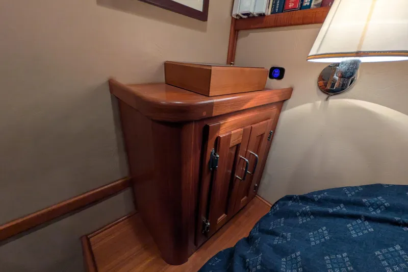 Slide: The Image of Wooden cabinet in 2005 American Tug 41 boat interior, with books and lamp. - 55