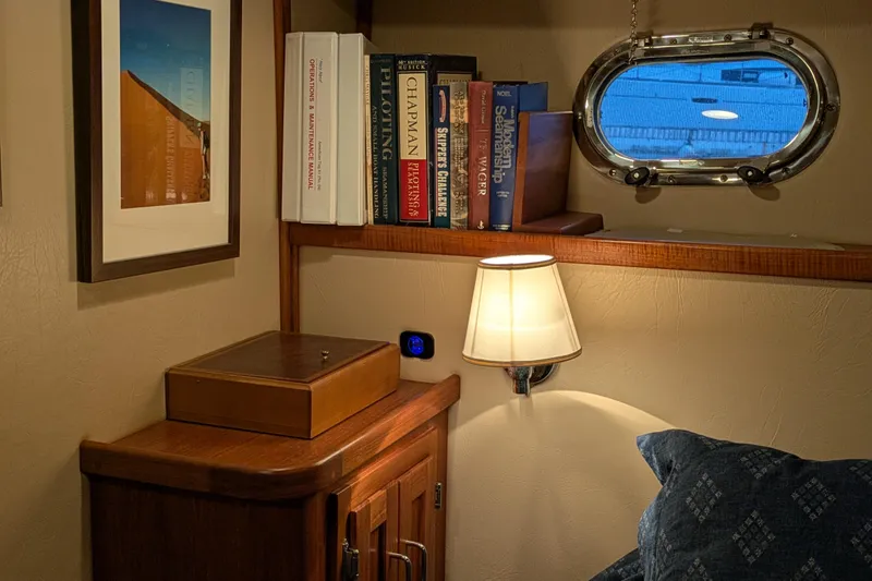 Slide: The Image of Cozy cabin interior of 2005 American Tug 41 with books, lamp, and porthole view. - 57