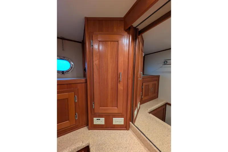 Slide: The Image of Wooden cabinetry inside 2005 American Tug 41 boat, featuring polished finish and built-in outlets. - 61