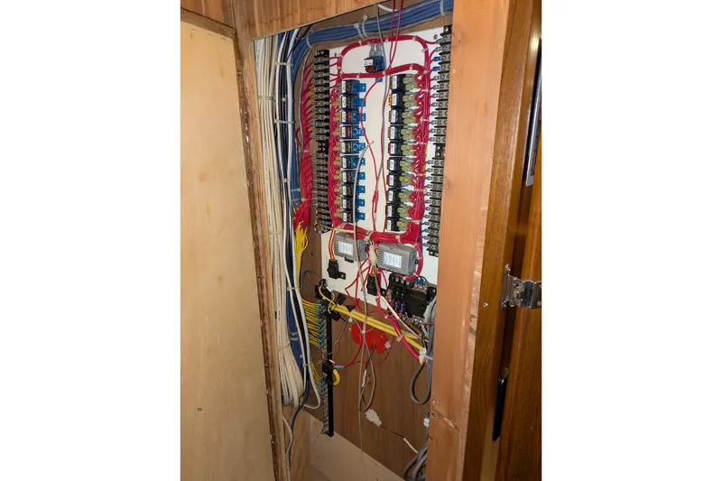 Slide: The Image of Electrical panel inside a 2005 American Tug 41 boat, showcasing wiring and circuit breakers. - 62