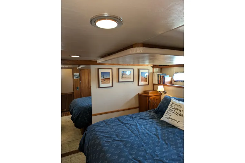 Slide: The Image of Cozy cabin interior of 2005 American Tug 41 with bed, artwork, and nautical decor. - 65