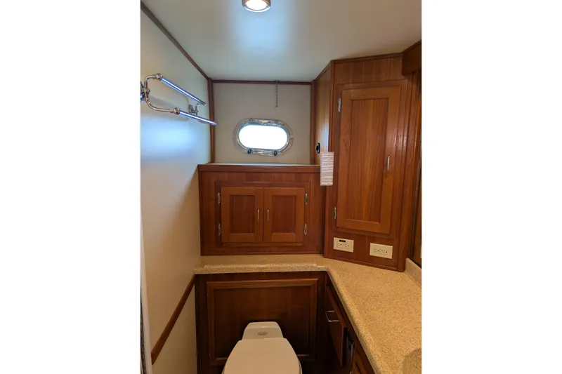 Slide: The Image of Bathroom interior of 2005 American Tug 41 with wooden cabinets and porthole window. - 68