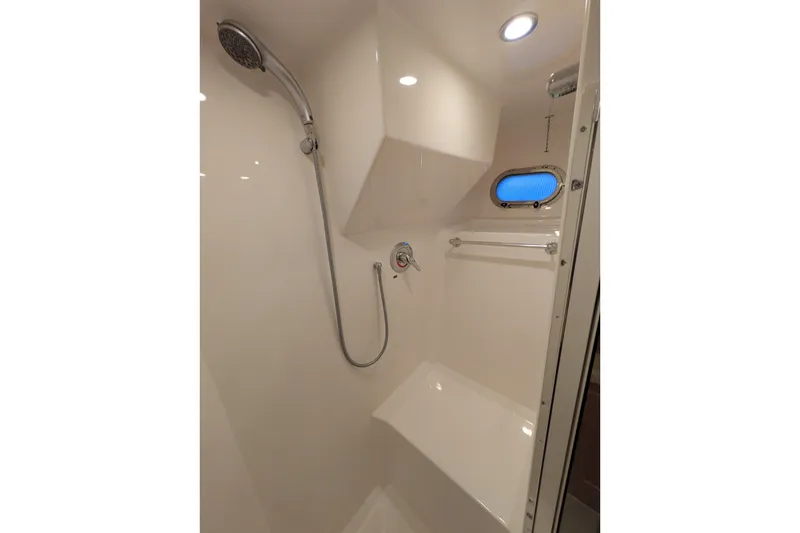 Slide: The Image of Shower area in 2005 American Tug 41 boat, featuring modern fixtures and a porthole window. - 70
