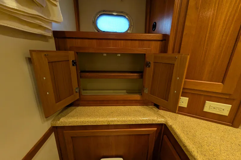 Slide: The Image of Interior of 2005 American Tug 41 with open wooden cabinet and countertop. - 72