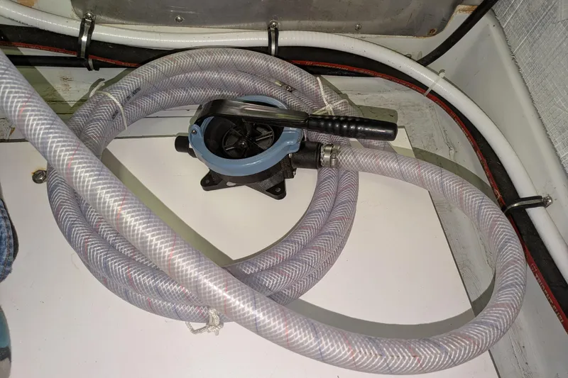 Slide: The Image of Coiled hose and pump in 2005 American Tug 41 boat interior. - 82